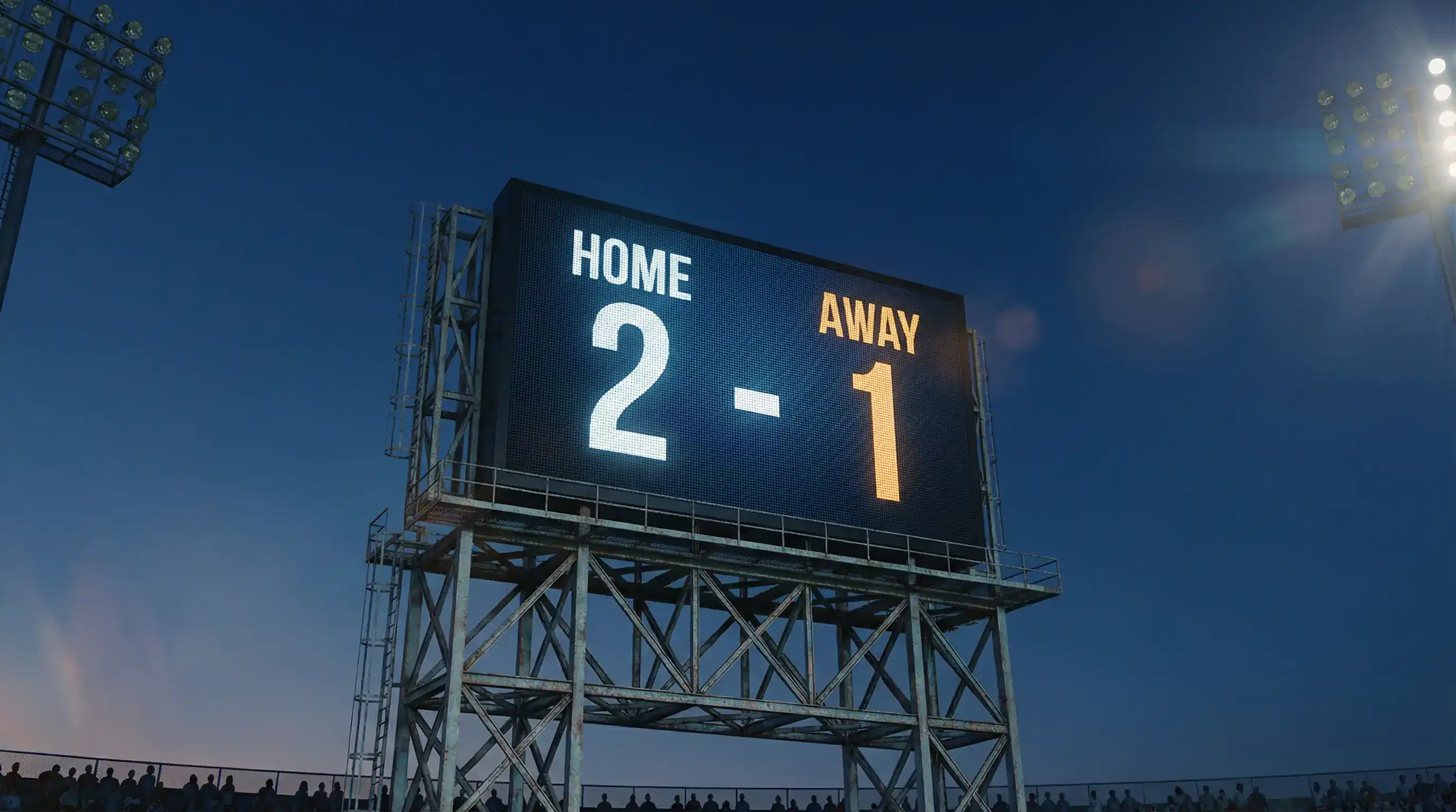 Nærbillede af en digital resultattavle på et fodboldstadion der viser holdnavne og kampstatus